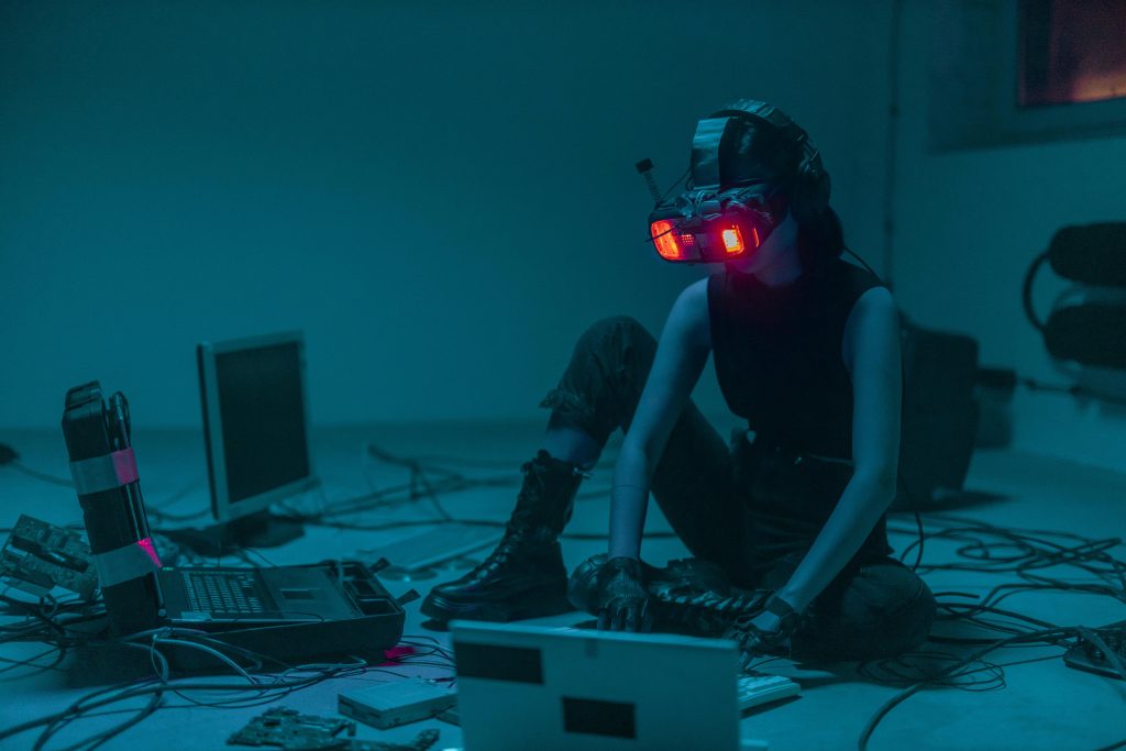 A person in a VR headset hacking in a moody, neon-lit environment.